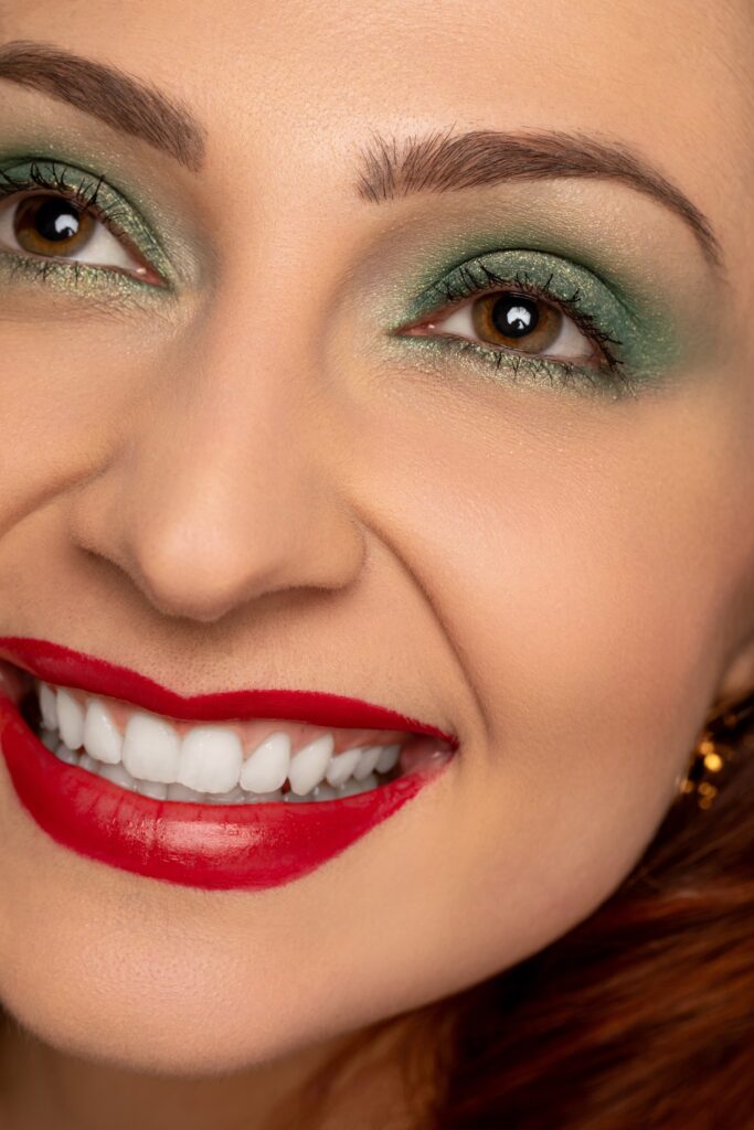 Portrait beauté d’une femme souriante avec maquillage coloré et lumineux de noel