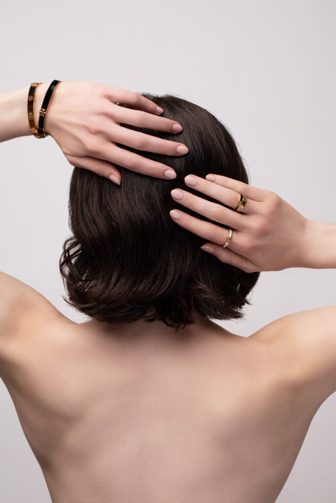 Femme de dos portant un bijou raffiné, mise en valeur minimaliste et élégante