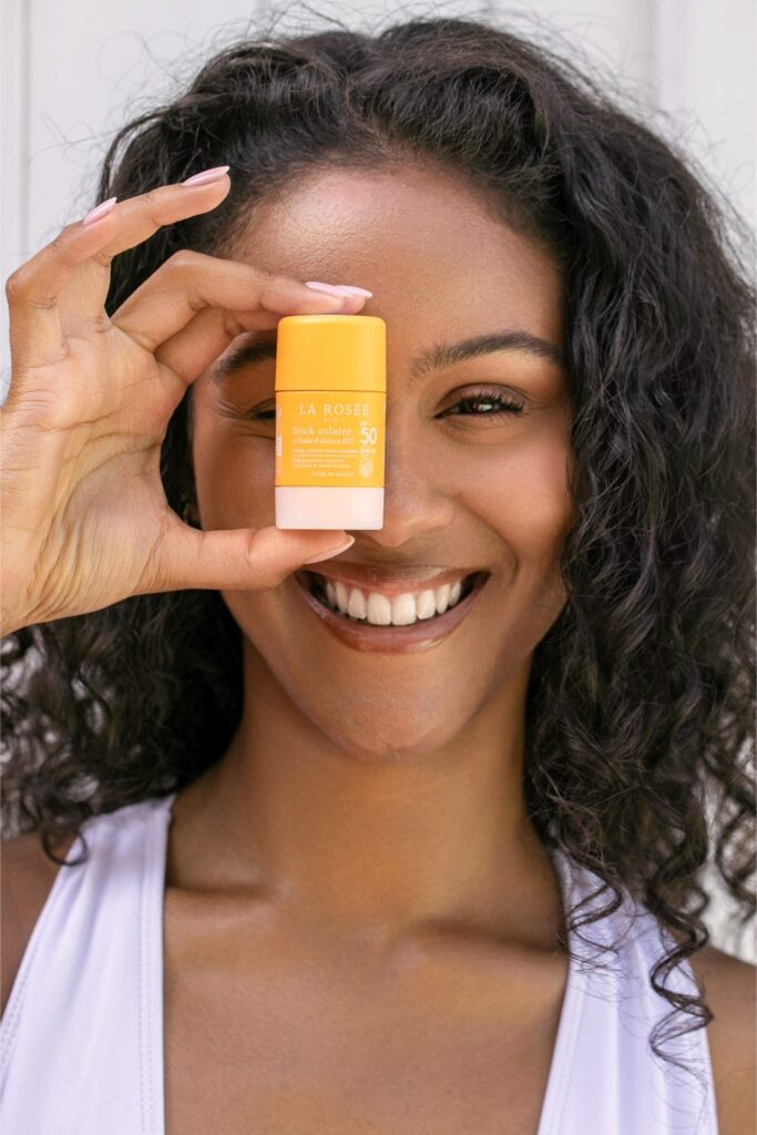 portrait beauté d'une femme tenant un produit cosmétique La Rosée devant le visage