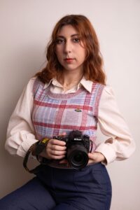 Stéphanie photographe à Lyon tenant un appareil photo Nikon, portrait créatif en studio