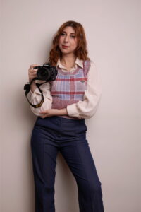 photographe à Lyon tenant un appareil photo Nikon, portrait naturel en studio
