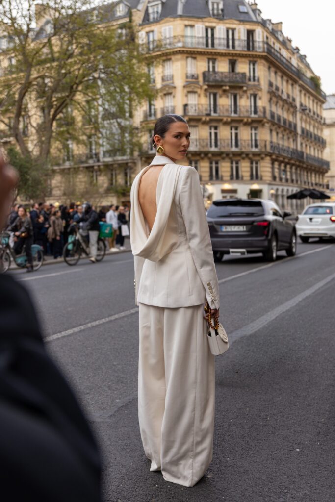street style féminin dans une rue de Paris devant une architecture haussmannienne